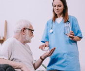 nurse giving medicine to senior man
