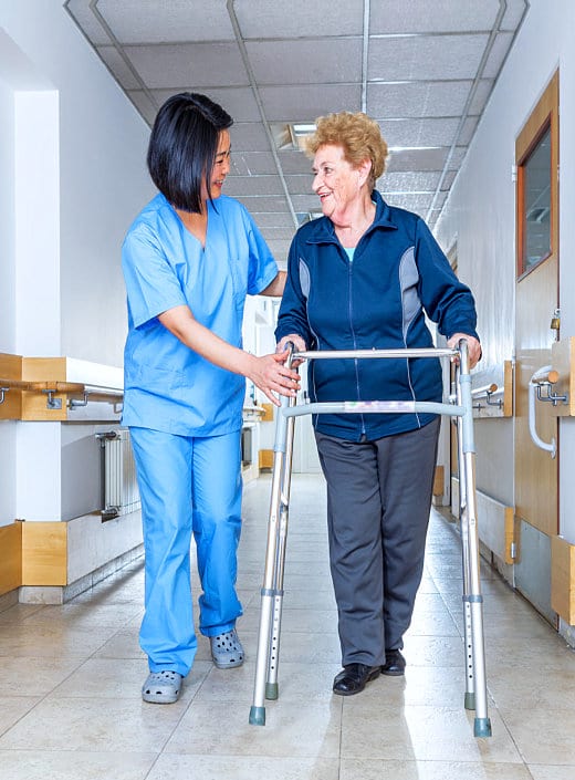 caregiver helping senior woman in walking